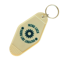 Load image into Gallery viewer, More Cats, Less Cat Calling Keychain
Equal parts protest and purr.

A retro motel-style tag with zero tolerance for street sleaze. Molded in buttercream plastic with a punch of deep green text and a bold daisy, it says what you’re thinking: MORE CATS, LESS CAT CALLING.

Clip it to your keys like brass knuckles for the modern feminist.  Fierce, unapologetic, loud, feral and decidedly not here for your unsolicited commentary.
	•	3.8” x 2” vintage motel shape
	•	Chunky molded plastic with raised lettering
	•	D